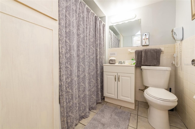 bathroom featuring vanity, tile flooring, toilet, and tile walls