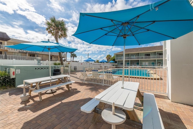 view of patio featuring a balcony and a community pool