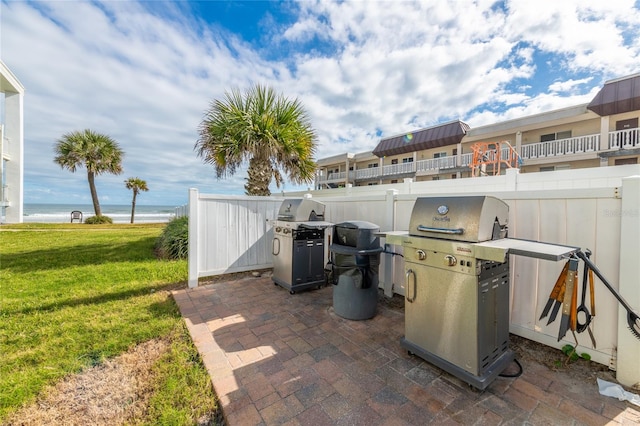 view of terrace with a balcony, area for grilling, and a water view