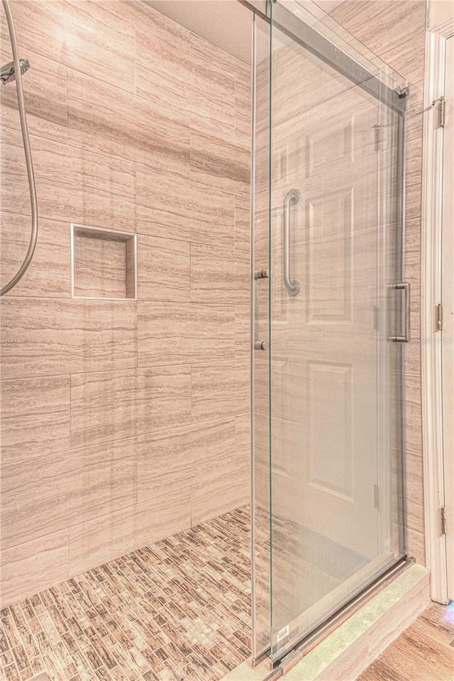 bathroom featuring a shower with door