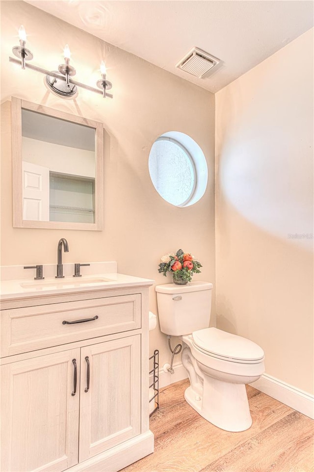 bathroom featuring vanity, hardwood / wood-style flooring, and toilet