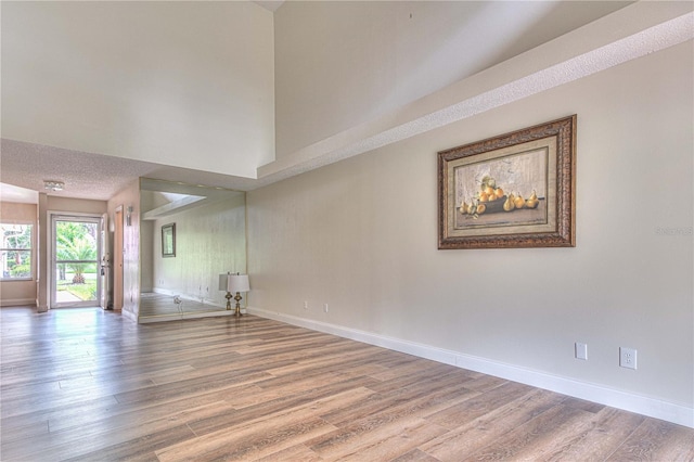 unfurnished room featuring wood-type flooring and a textured ceiling