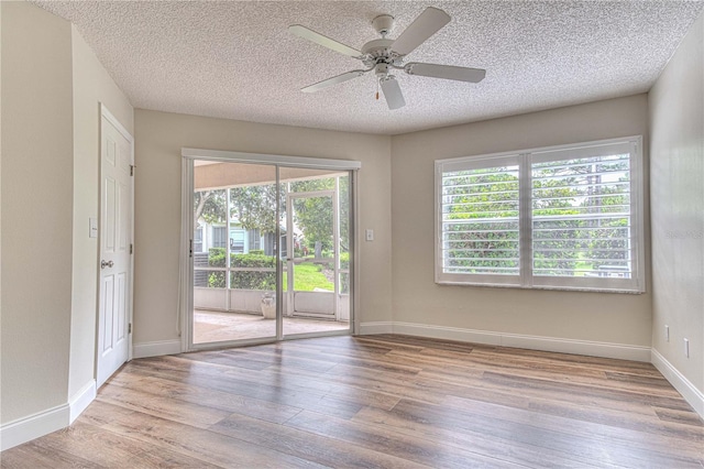 empty room with ceiling fan, a textured ceiling, and light wood-type flooring