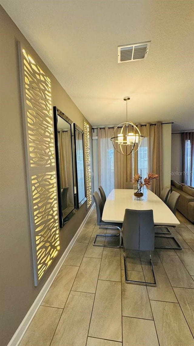 dining space featuring light tile flooring and a chandelier