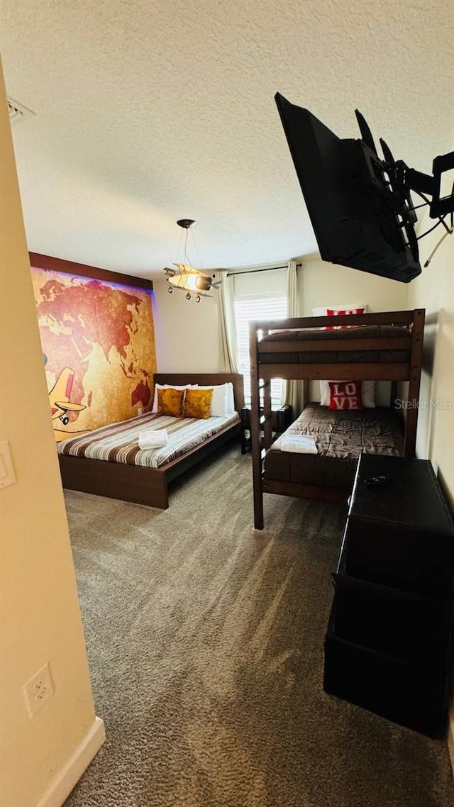 bedroom featuring dark colored carpet, a textured ceiling, and an inviting chandelier