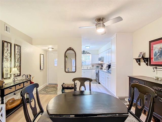 dining space with light wood-type flooring and ceiling fan