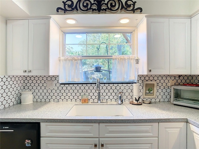 kitchen featuring dishwasher, sink, white cabinets, and decorative backsplash