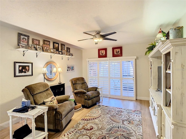 living area featuring light hardwood / wood-style flooring and ceiling fan