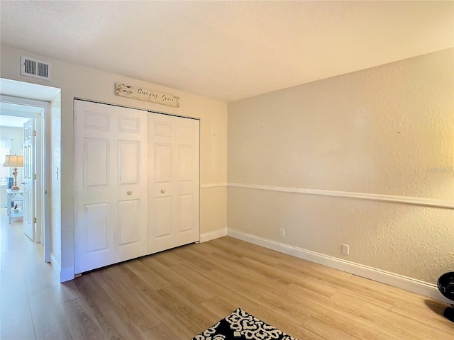 unfurnished bedroom with wood-type flooring and a closet