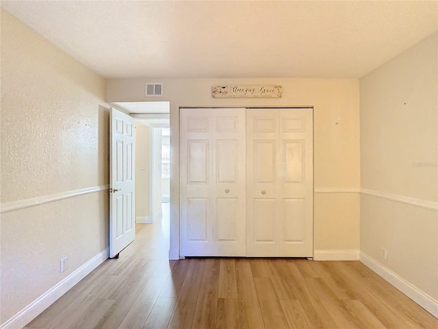 unfurnished bedroom featuring a closet and light wood-type flooring