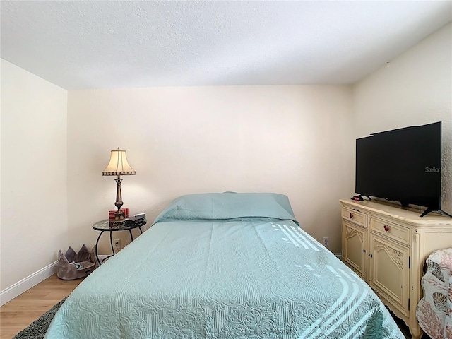 bedroom featuring a textured ceiling and light hardwood / wood-style floors