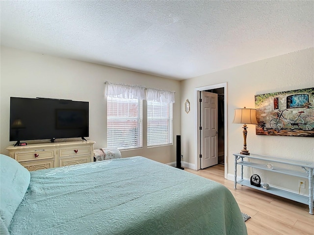 bedroom featuring a textured ceiling and light wood-type flooring