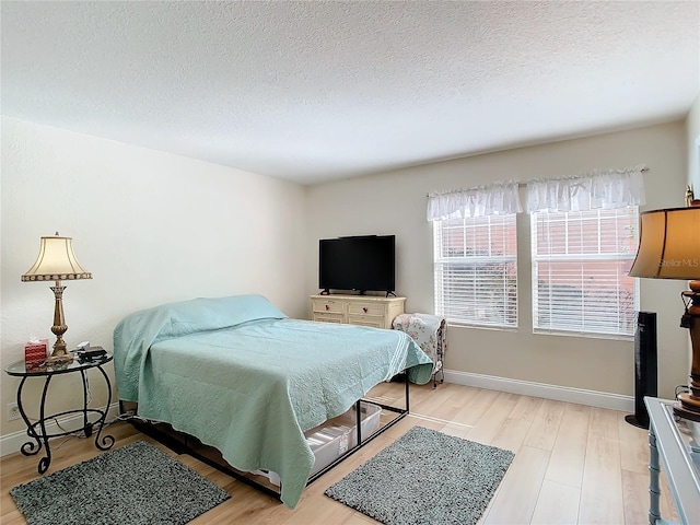 bedroom featuring a textured ceiling and light wood-type flooring