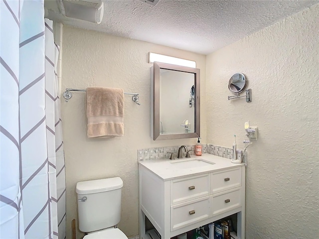 bathroom with vanity, a textured ceiling, and toilet