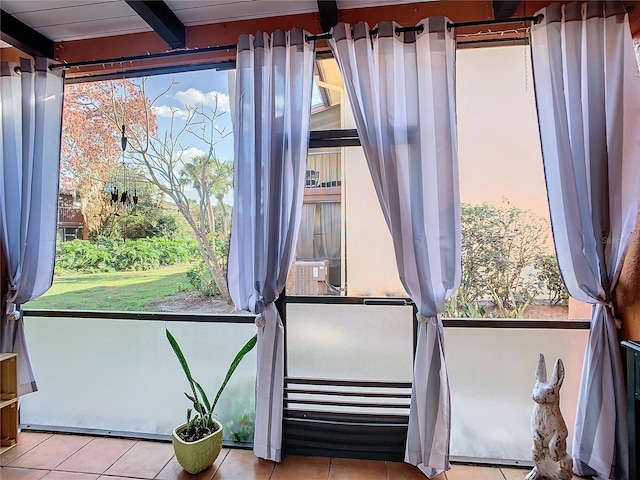 miscellaneous room featuring beamed ceiling, plenty of natural light, and light tile patterned floors