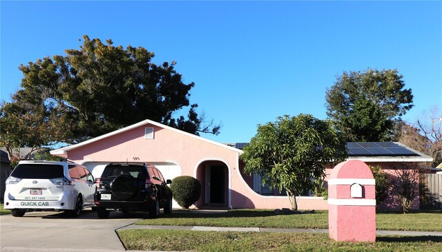 595 Benjamin Franklin Pl, Orlando, FL 32809 - view of front of property featuring solar panels, a front yard, and a garage