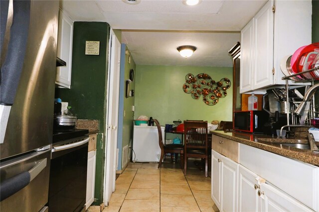 595 Benjamin Franklin Pl, Orlando, FL 32809 - kitchen featuring white cabinets, appliances with stainless steel finishes, dark stone counters, and light tile flooring