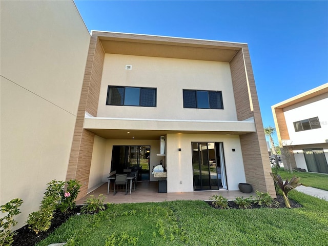 rear view of property with a lawn and a patio