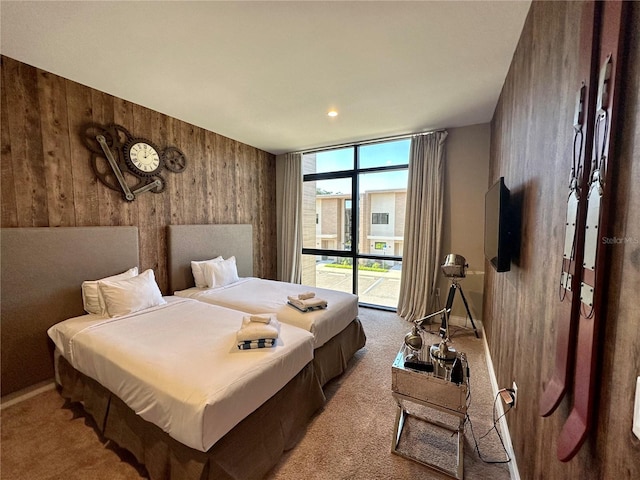 bedroom featuring wood walls, light carpet, access to outside, and a wall of windows