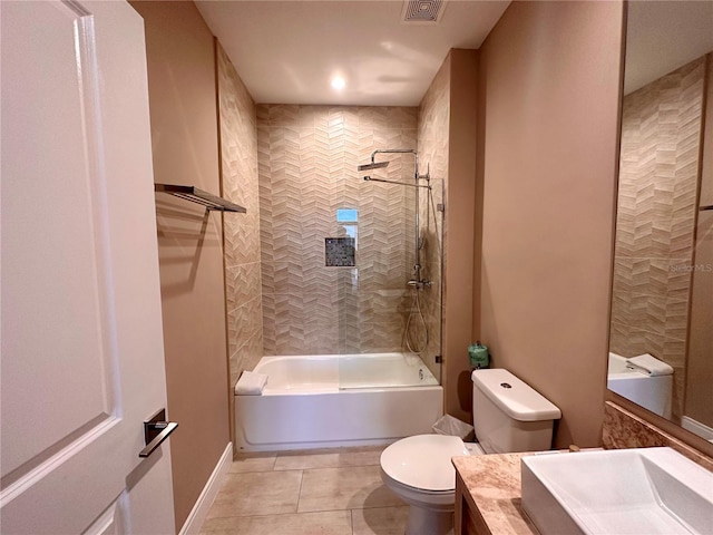 full bathroom with tiled shower / bath, toilet, tile floors, and vanity