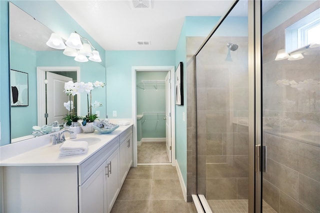 bathroom featuring tile floors, a shower with shower door, and large vanity