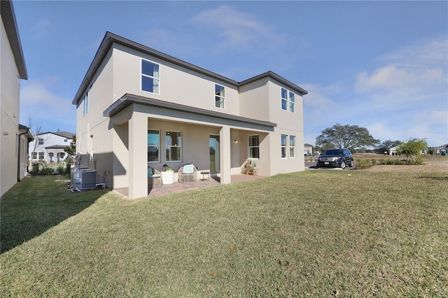 back of property with a lawn, a patio, and central AC unit