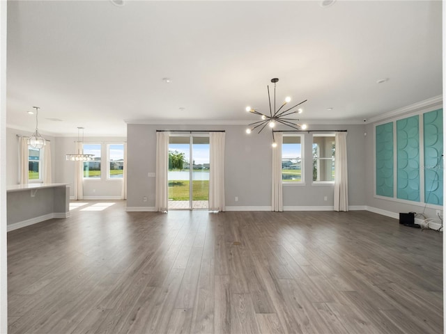 unfurnished living room with crown molding, an inviting chandelier, and dark hardwood / wood-style flooring