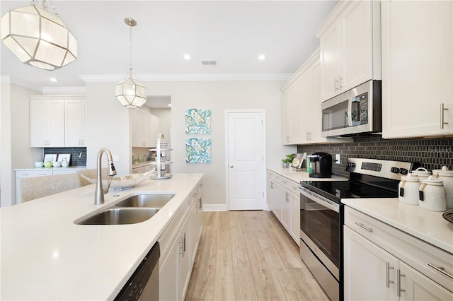 kitchen featuring sink, decorative light fixtures, white cabinetry, and stainless steel appliances