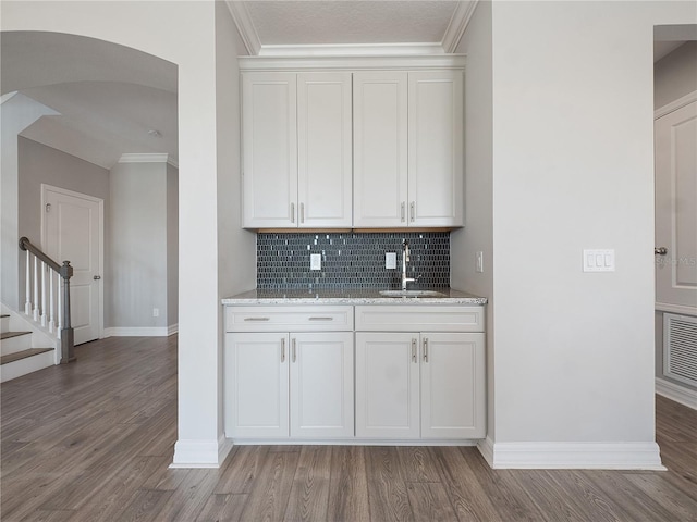 kitchen featuring ornamental molding, wood-type flooring, white cabinetry, and sink