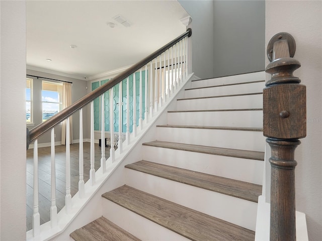 stairway featuring crown molding and hardwood / wood-style flooring