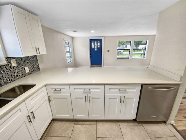 kitchen with light tile floors, white cabinetry, backsplash, and sink