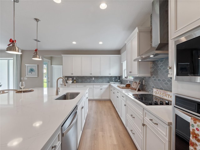 kitchen featuring white cabinetry, stainless steel appliances, wall chimney exhaust hood, and sink