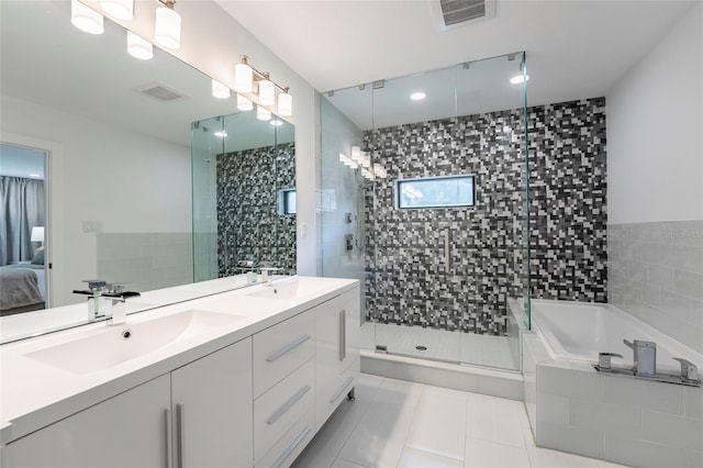 bathroom featuring tile patterned flooring, vanity, tile walls, and plus walk in shower