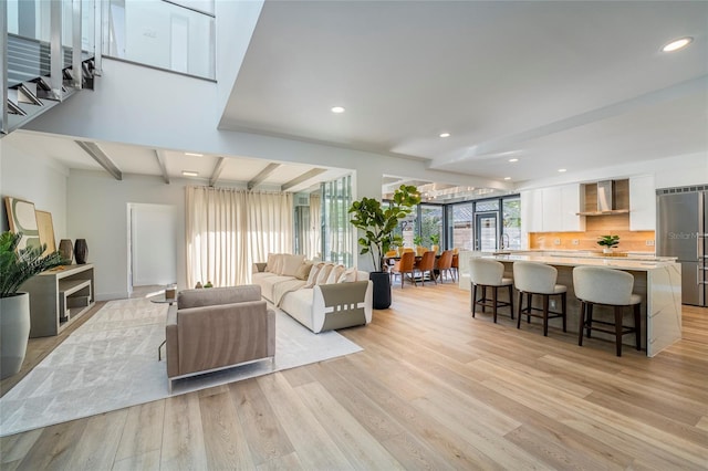 living room with beamed ceiling and light hardwood / wood-style floors