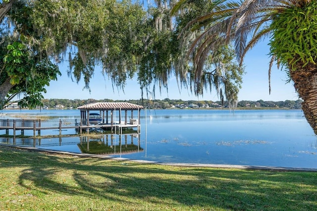 dock area featuring a lawn and a water view