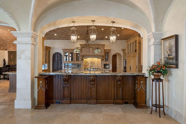 interior space featuring pendant lighting, decorative columns, and brick ceiling