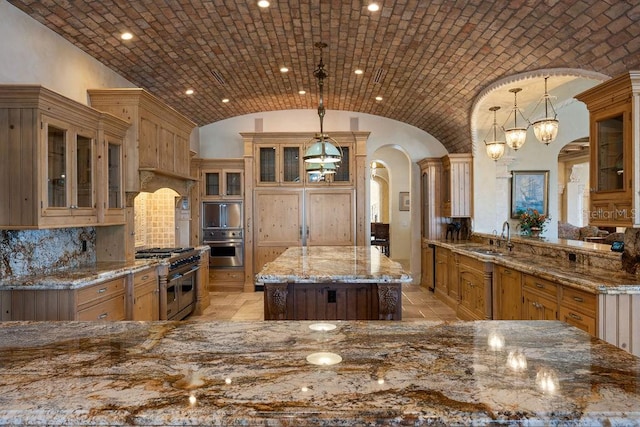 kitchen with decorative light fixtures, stainless steel appliances, and brick ceiling