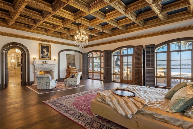 living room featuring coffered ceiling, a notable chandelier, crown molding, a water view, and dark hardwood / wood-style floors