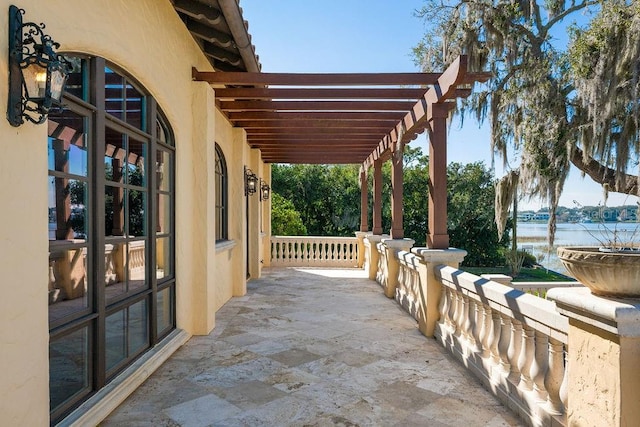 view of patio / terrace with a pergola and a water view