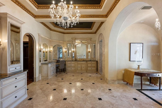 interior space with a notable chandelier, a raised ceiling, a towering ceiling, and ornamental molding