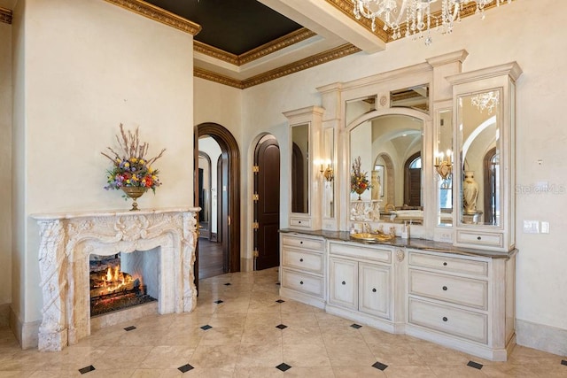 bathroom with vanity, a premium fireplace, ornamental molding, a towering ceiling, and tile floors