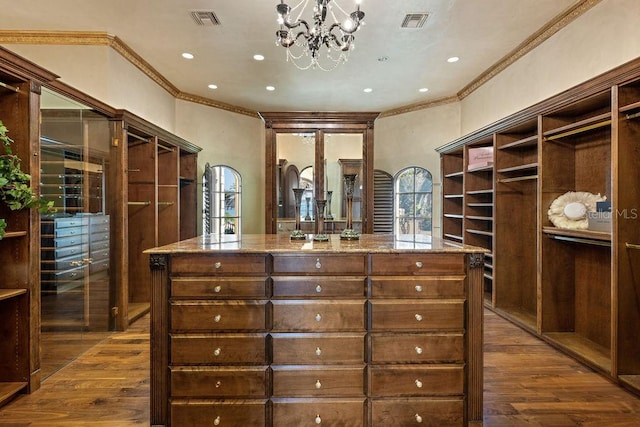 walk in closet featuring an inviting chandelier and dark hardwood / wood-style floors