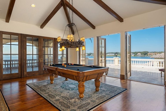 recreation room with dark hardwood / wood-style floors, billiards, a water view, lofted ceiling with beams, and french doors