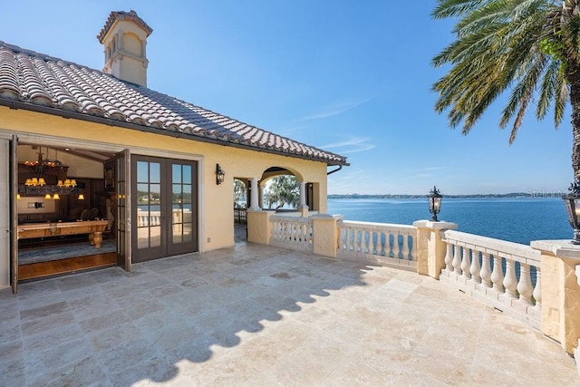 view of patio with french doors and a water view