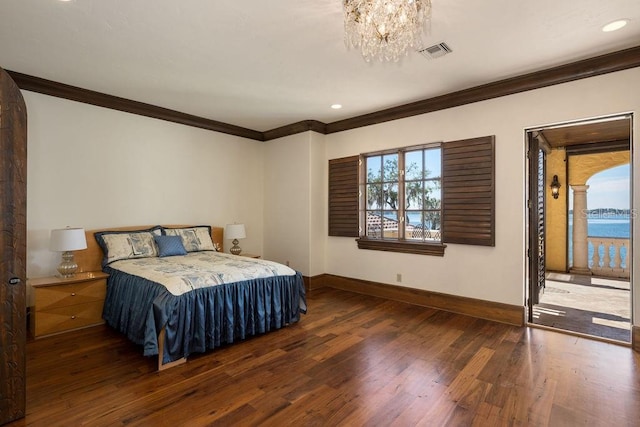 bedroom featuring ornamental molding, a chandelier, dark hardwood / wood-style floors, and a water view