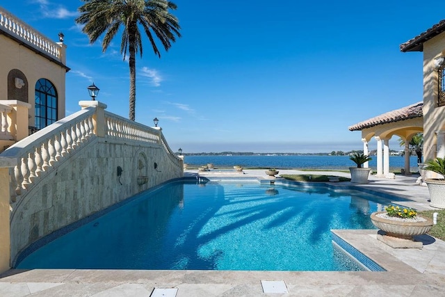 view of pool with a patio area and a water view