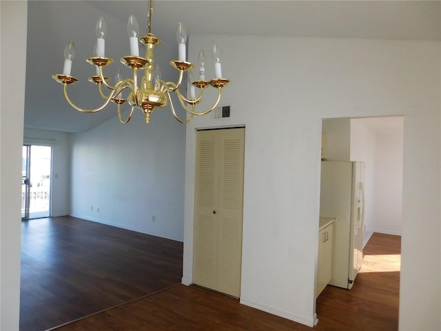 empty room with dark hardwood / wood-style flooring, a notable chandelier, and vaulted ceiling