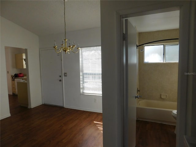 bathroom with wood-type flooring, a chandelier, shower / washtub combination, vaulted ceiling, and toilet