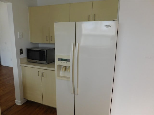 kitchen featuring white fridge with ice dispenser, dark hardwood / wood-style floors, and cream cabinets