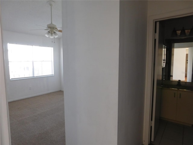 corridor featuring sink and dark carpet